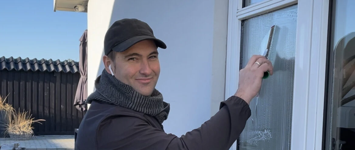 Introduktion billede af Dan Hulgaard, der pudser vinduer på en traditoinel måde