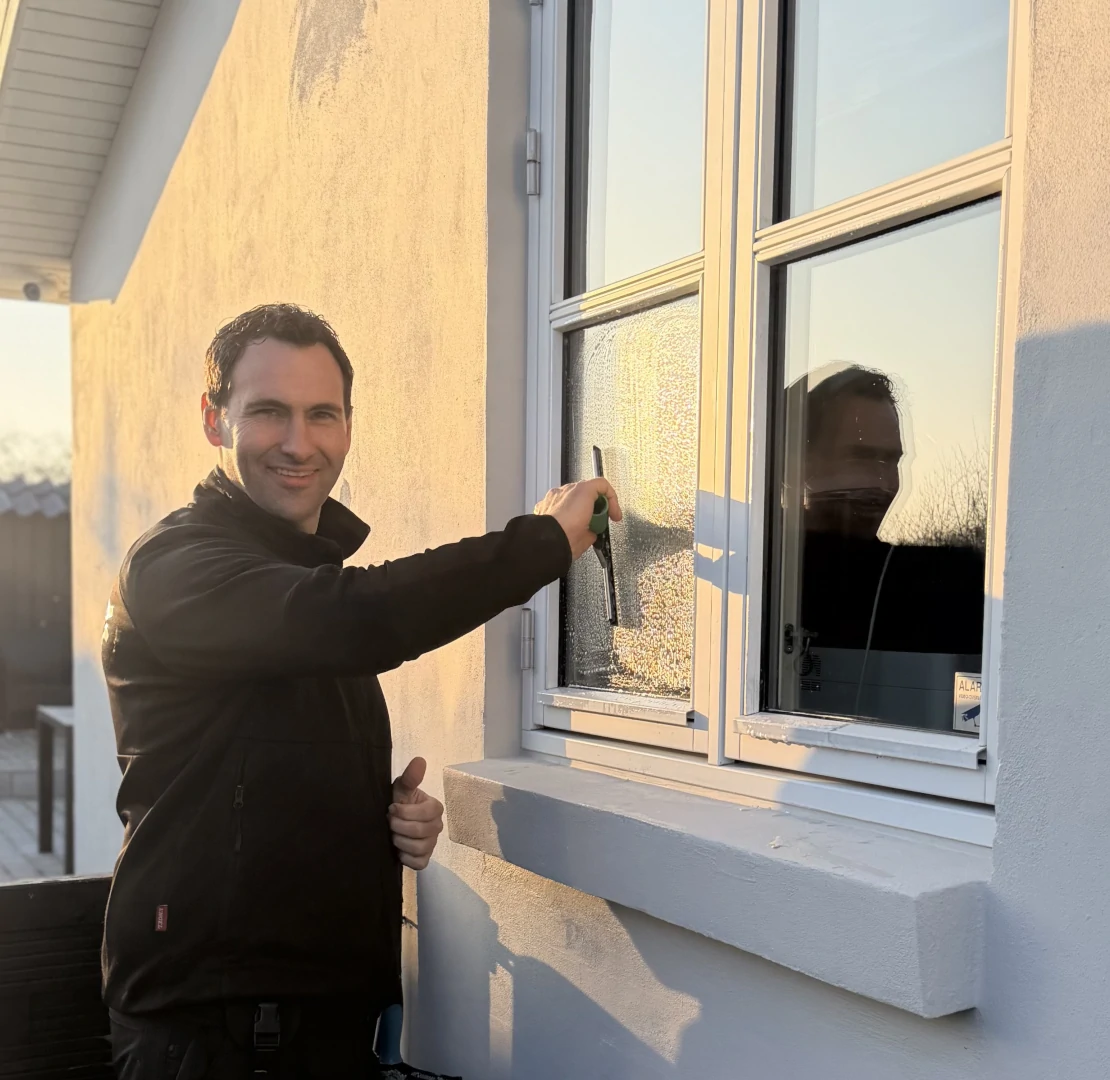 billede af Dan Hulgaard, der vasker vinduer på en traditionel måde