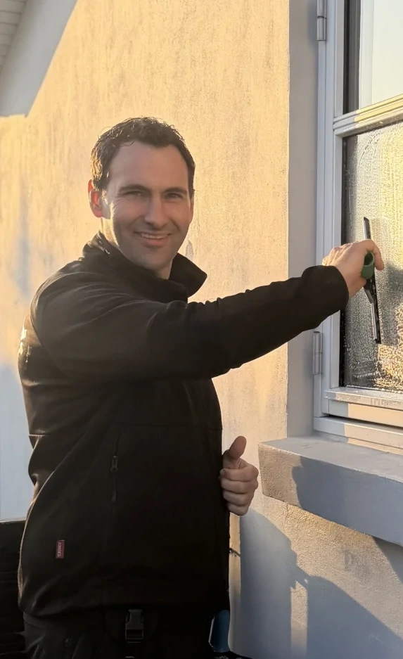 billede af Dan Hulgaard, der vasker vinduer på en traditionel måde